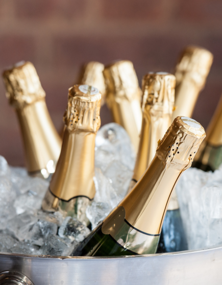Auf dem Bild sind mehrere Champagner Flaschen im Champagner Kühler mit Eis zu sehen.