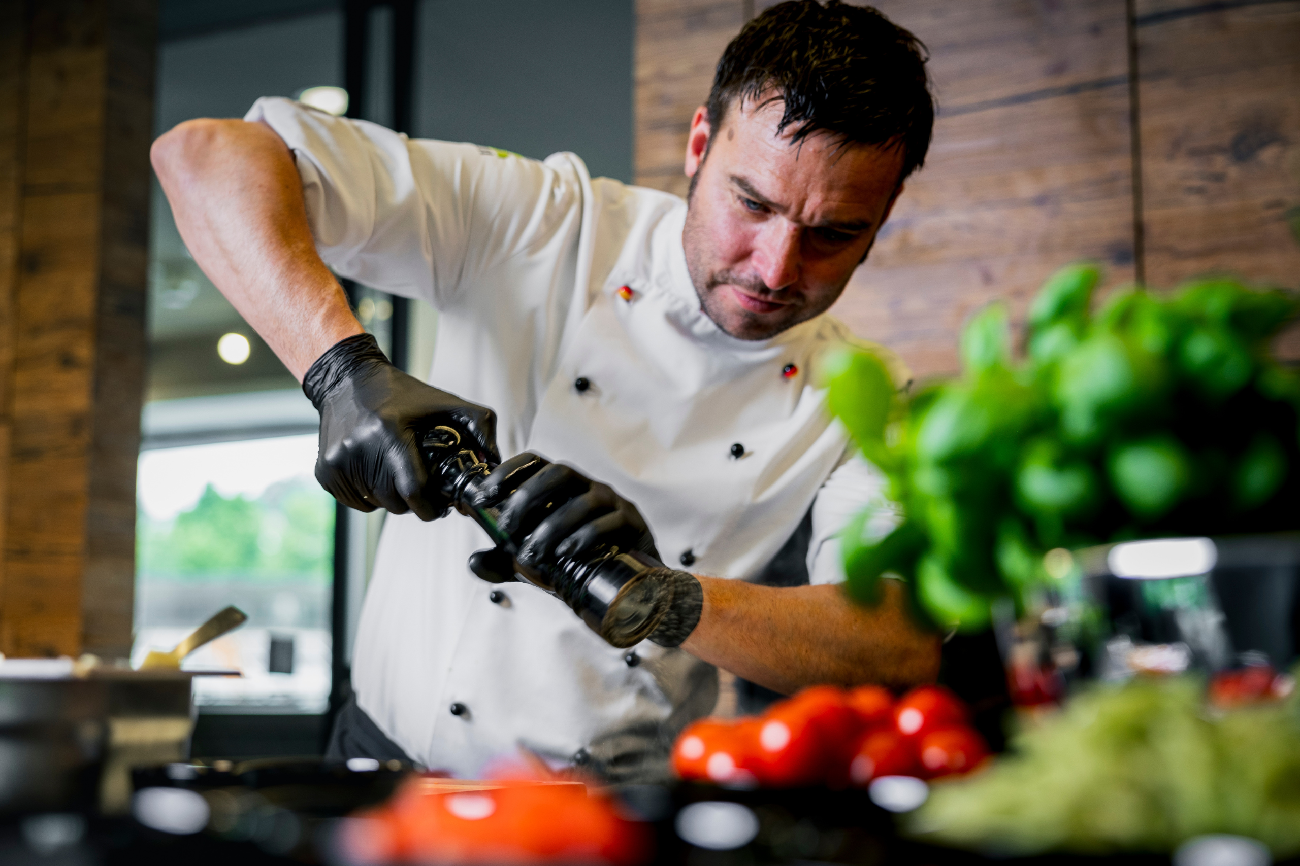 Hier sieht man Kilian beim würzen und zubereiten eines Menüs in der offenen Showküche von Savoro.
